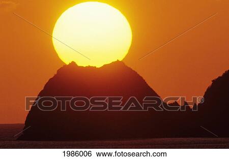 Mexico, Manzanillo, Sun Setting In Orange Sky Over Ocean And Silhouetted Hill. View Large Photo Image Stock Photograph - Mexico, Manzanillo, Sun Setting In Orange Sky Over Ocean And Silhouetted Hill.. Fotosearch