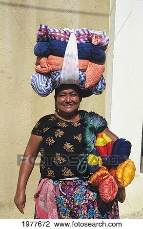 Stock Image - Mexico, Puerto Escondido, Local Woman In Marketplace With Bundles Balanced On Her Head.. Fotosearch