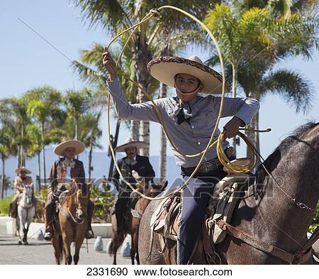 Mexico, specific type of Mexican rodeo here in parade; Puerto Vallarta, The traditional Mexican charro is known for colorful clothing and participating in coleadero y charreada View Large Photo Image Stock Image - Mexico, specific type of Mexican rodeo here in parade; Puerto Vallarta, The traditional Mexican charro is known for colorful clothing and participating in coleadero y charreada. Fotosearch