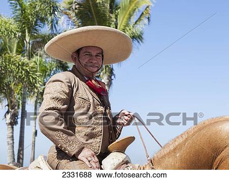 Mexico, specific type of Mexican rodeo here in parade; Puerto Vallarta, The traditional Mexican charro is known for colorful clothing and participating in coleadero y charreada View Large Photo Image Stock Photo - Mexico, specific type of Mexican rodeo here in parade; Puerto Vallarta, The traditional Mexican charro is known for colorful clothing and participating in coleadero y charreada. Fotosearch