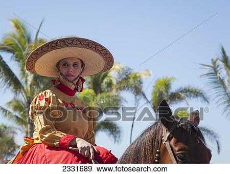 Mexico, specific type of Mexican rodeo here in parade; Puerto Vallarta, The traditional Mexican charro is known for colorful clothing and participating in coleadero y charreada View Large Photo Image Stock Photo - Mexico, specific type of Mexican rodeo here in parade; Puerto Vallarta, The traditional Mexican charro is known for colorful clothing and participating in coleadero y charreada. Fotosearch