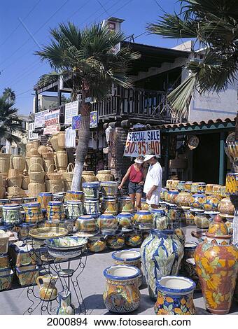 Picture - Mexico, Tijuana, Couple Wanders Through Marketplace Stand, Ceramic Pots. Fotosearch