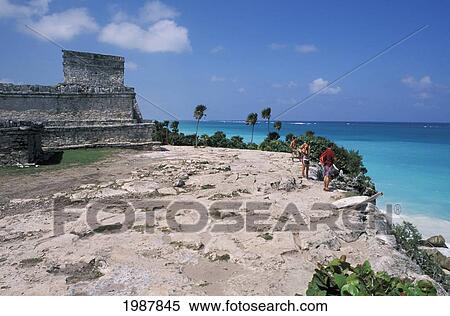 Mexico, Yucatan Peninsula, Visitors standing on rocky cliff near ruins; Tulum View Large Photo Image Stock Photography - Mexico, Yucatan Peninsula, Visitors standing on rocky cliff near ruins; Tulum. Fotosearch