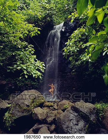 Micronesia, Kosrae, Sypian Falls, Woman At Foot Of Waterfall, Large Rocks In Foreground View Large Photo Image Stock Image - Micronesia, Kosrae, Sypian Falls, Woman At Foot Of Waterfall, Large Rocks In Foreground. Fotosearch