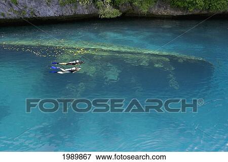 Stock Photo - Micronesia, Palua, Couple With Scuba Gear Explore A Shallow Wreck.. Fotosearch