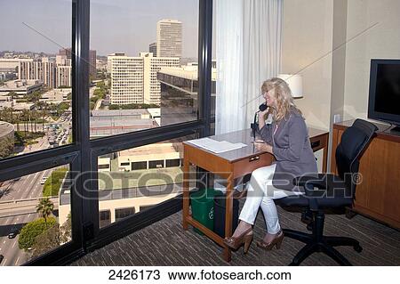 Middle aged woman on the phone in a hotel room; Los Angeles, California, United States of America View Large Photo Image Stock Image - Middle aged woman on the phone in a hotel room; Los Angeles, California, United States of America. Fotosearch