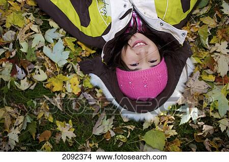 Middle Eastern Girl Lying In Autumn Leaves Outside Esl School; Guelph Ontario Canada View Large Photo Image Picture - Middle Eastern Girl Lying In Autumn Leaves Outside Esl School; Guelph Ontario Canada. Fotosearch