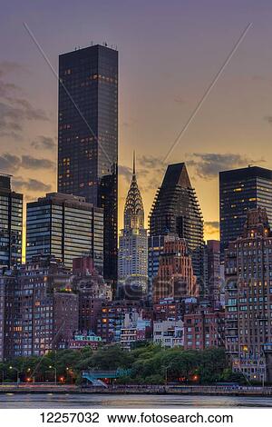 Stock Image - Midtown Manhattan skyline with Chrysler Building at sunset as viewed from Roosevelt Island; New York City, New York, United States of America. Fotosearch