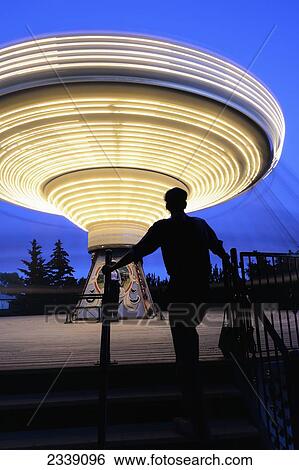 Stock Photograph - Midway Swing Ride And Operator At Heritage Park; Calgary, Alberta, Canada. Fotosearch