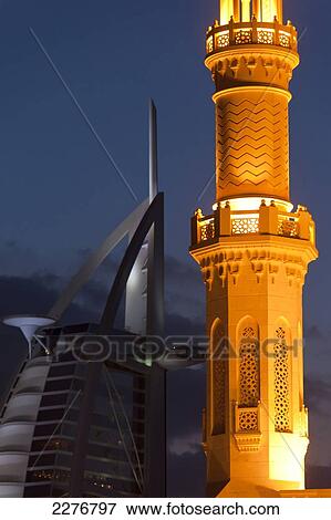 Minaret of small mosque and Burj Al Arab hotel at dusk; Dubai, United Arab Emirates View Large Photo Image Stock Photo - Minaret of small mosque and Burj Al Arab hotel at dusk; Dubai, United Arab Emirates. Fotosearch