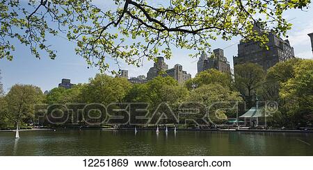 Stock Photo - Miniature sailboats in a lake in a park; New York City, New York, United States of America. Fotosearch