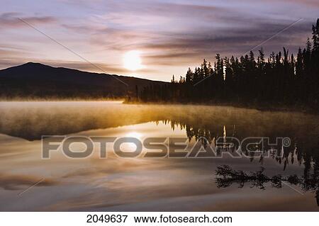Stock Photo - Mist Over Lake At Sunrise, Northern British Columbia. Fotosearch