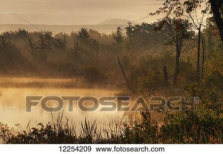 Stock Photo - Mist over the water at sunrise; Foster, Quebec, Canada. Fotosearch