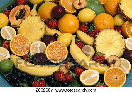 Stock Photo - Mixed Fruits With Oranges, Lemons, Papaya And Pineapple Cut In Half, Banana And Grapes. Fotosearch