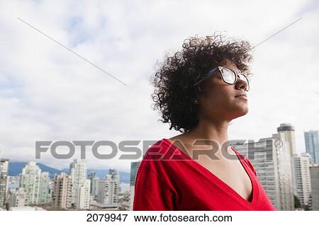 Stock Photo - Mixed Race Woman In Front Of Cityscape; Vancouver, British Columbia, Canada. Fotosearch