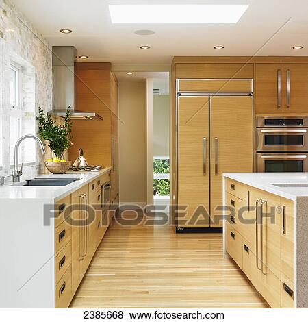 Stock Photo - Modern galley kitchen with edge grain oak cabinets; Victoria, Vancouver Island, British Columbia. Fotosearch