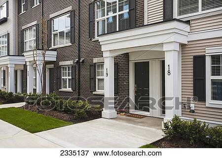 Modern Townhouse Row Exterior With Sidewalks And Porches; Surrey, British Columbia, Canada View Large Photo Image Stock Photo - Modern Townhouse Row Exterior With Sidewalks And Porches; Surrey, British Columbia, Canada. Fotosearch