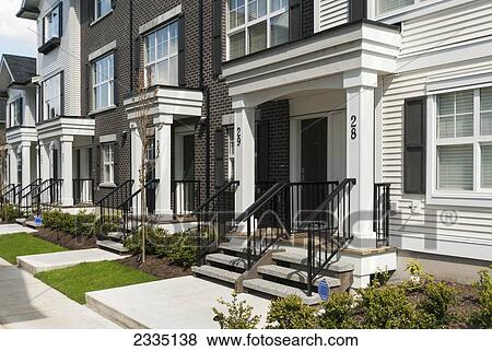 Stock Photo - Modern Townhouse Row Exterior With Sidewalks And Porches; Surrey, British Columbia, Canada. Fotosearch