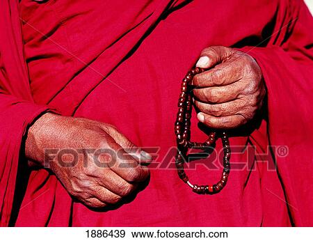 Stock Photo - Monk In Red Robe Holding Prayer Beads. Fotosearch