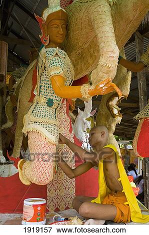 Stock Photo - Monk Working On Wax Float Statues. Fotosearch
