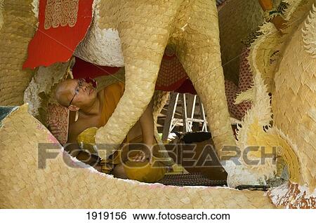Stock Photograph - Monk Working On Wax Float Statues. Fotosearch