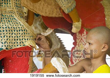 Stock Photography - Monk Working On Wax Float Statues. Fotosearch