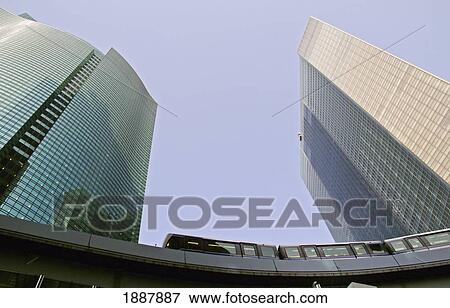 Stock Photo - Monorail Train Passing Two Office Buildings. Fotosearch