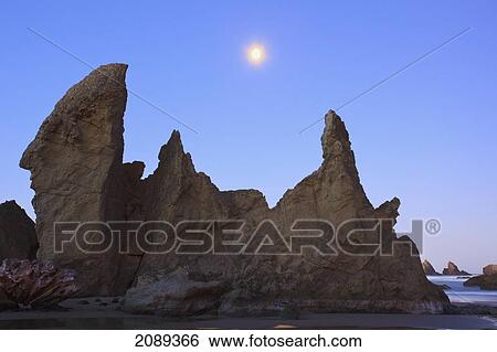 Moon Set Over Rock Formations At Low Tide, Bandon Beach; Oregon, United States Of America View Large Photo Image Stock Photograph - Moon Set Over Rock Formations At Low Tide, Bandon Beach; Oregon, United States Of America. Fotosearch