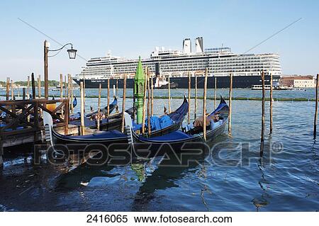 Moored gondolas with a departing Holand America Line, Nieuw Amsterdam Cruise Ship; Venice, Italy View Large Photo Image Stock Photography - Moored gondolas with a departing Holand America Line, Nieuw Amsterdam Cruise Ship; Venice, Italy. Fotosearch