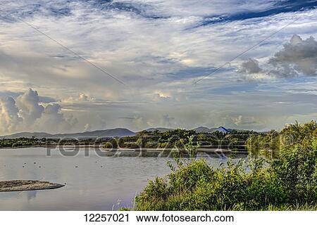 Stock Image - Morning clouds over McKinnon's Pond; St. John's, Antigua, West Indies. Fotosearch