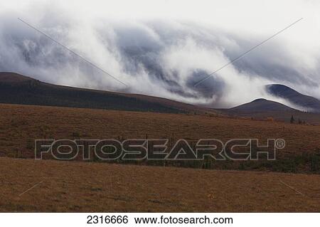 Stock Photograph - Morning Mist Rolls Over The Richardson Mountains Along The Dempster Highway; Yukon Canada. Fotosearch