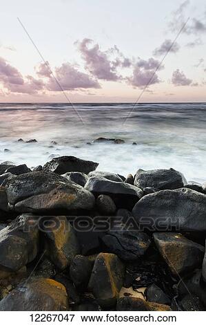 Morning surf and wet rocks along the coast; Wailua, Kauai, Hawaii, United States of America View Large Photo Image Stock Photo - Morning surf and wet rocks along the coast; Wailua, Kauai, Hawaii, United States of America. Fotosearch