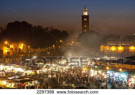 Stock Photo - Morocco, Food stalls in Djemaa El Fna with Koutoubia minaret in background at dusk; Marrakesh. Fotosearch