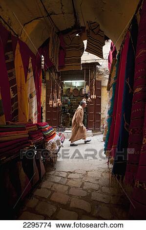 Morocco, Looking past clothes for sale in narrow passageway to man walking up alley; Fez View Large Photo Image Picture - Morocco, Looking past clothes for sale in narrow passageway to man walking up alley; Fez. Fotosearch
