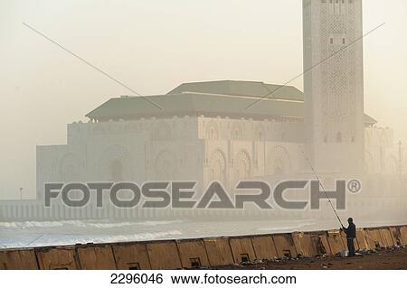 Morocco, Man fishing from sea wall in front of Hassan II mosque at dawn; Casablanca View Large Photo Image Stock Photograph - Morocco, Man fishing from sea wall in front of Hassan II mosque at dawn; Casablanca. Fotosearch