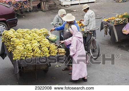 Stock Photo - Morocco, Marrakech, Medina, Customers buying bananas. Fotosearch