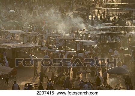Stock Photography - Morocco, People and food stalls in Place Djemaa el Fna at dusk; Marrakesh. Fotosearch