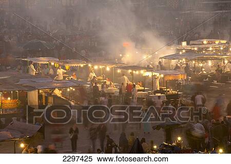 Stock Photography - Morocco, People and food stalls in Place Djemaa el Fna at dusk; Marrakesh. Fotosearch