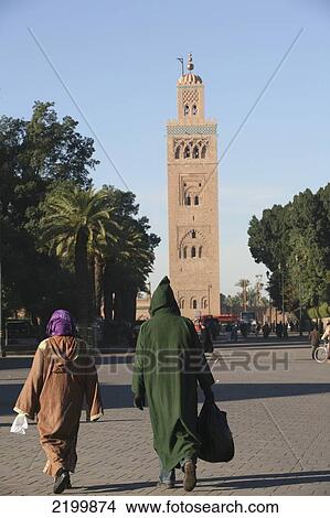Picture - Morocco, People In Djellaba; Marrakesh/ Marrakech/, Minaret Of Koutoubia Mosque. Fotosearch