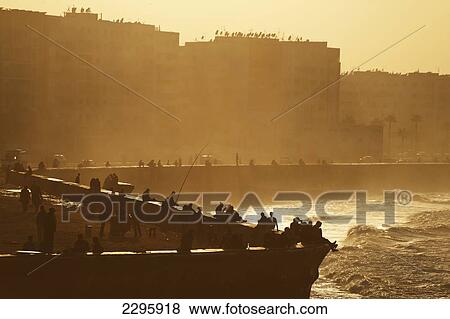 Morocco, People sitting and fishing at dusk from sea wall beside Hassan II Mosque; Casablanca View Large Photo Image Stock Photo - Morocco, People sitting and fishing at dusk from sea wall beside Hassan II Mosque; Casablanca. Fotosearch