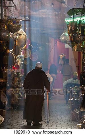 Stock Image - Morocco, Senior man walking on souk; Marrakesh. Fotosearch