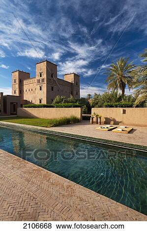 Stock Photo - Morocco, Swimming pool and main kasbah of Dar Ahlam Hotel; Skoura. Fotosearch