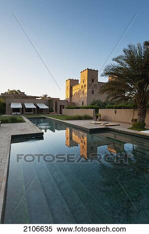 Stock Photography - Morocco, Swimming pool of Dar Ahlam Hotel with main kasbah in background at dawn; Skoura. Fotosearch