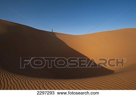 Morocco, Tourist walking along top of dune in Erg Chebbi area; Sahara Desert near Merzouga View Large Photo Image Stock Image - Morocco, Tourist walking along top of dune in Erg Chebbi area; Sahara Desert near Merzouga. Fotosearch
