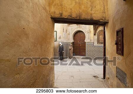 Stock Image - Morocco, Two men outside entrance to Sidi Tijani Mosque; Fez. Fotosearch