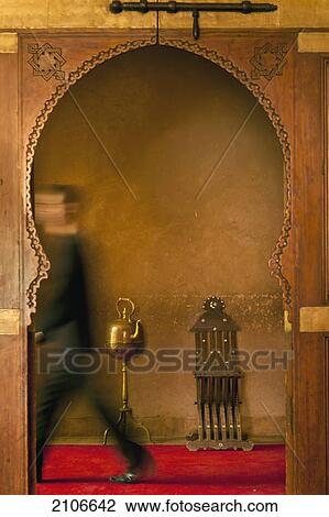 Stock Image - Morocco, Waiter walking past doorway in Dar Ahlam hotel; Skoura. Fotosearch