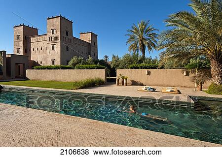 Stock Photo - Morocco, Woman swimming in pool of Dar Ahlam Hotel; Skoura. Fotosearch