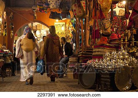 Stock Image - Morocco, Women walking through souk; Marrakesh. Fotosearch