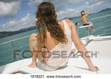 Stock Image - Mother And Baby Looking At Boy Sitting On Gang Plank. Fotosearch