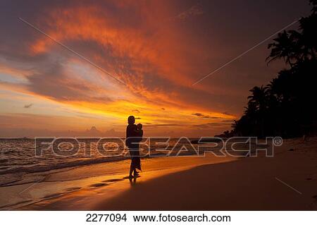 Picture - Mother and baby watching sunset on beach, near Unawatuna; Thalpe, Sri Lanka. Fotosearch